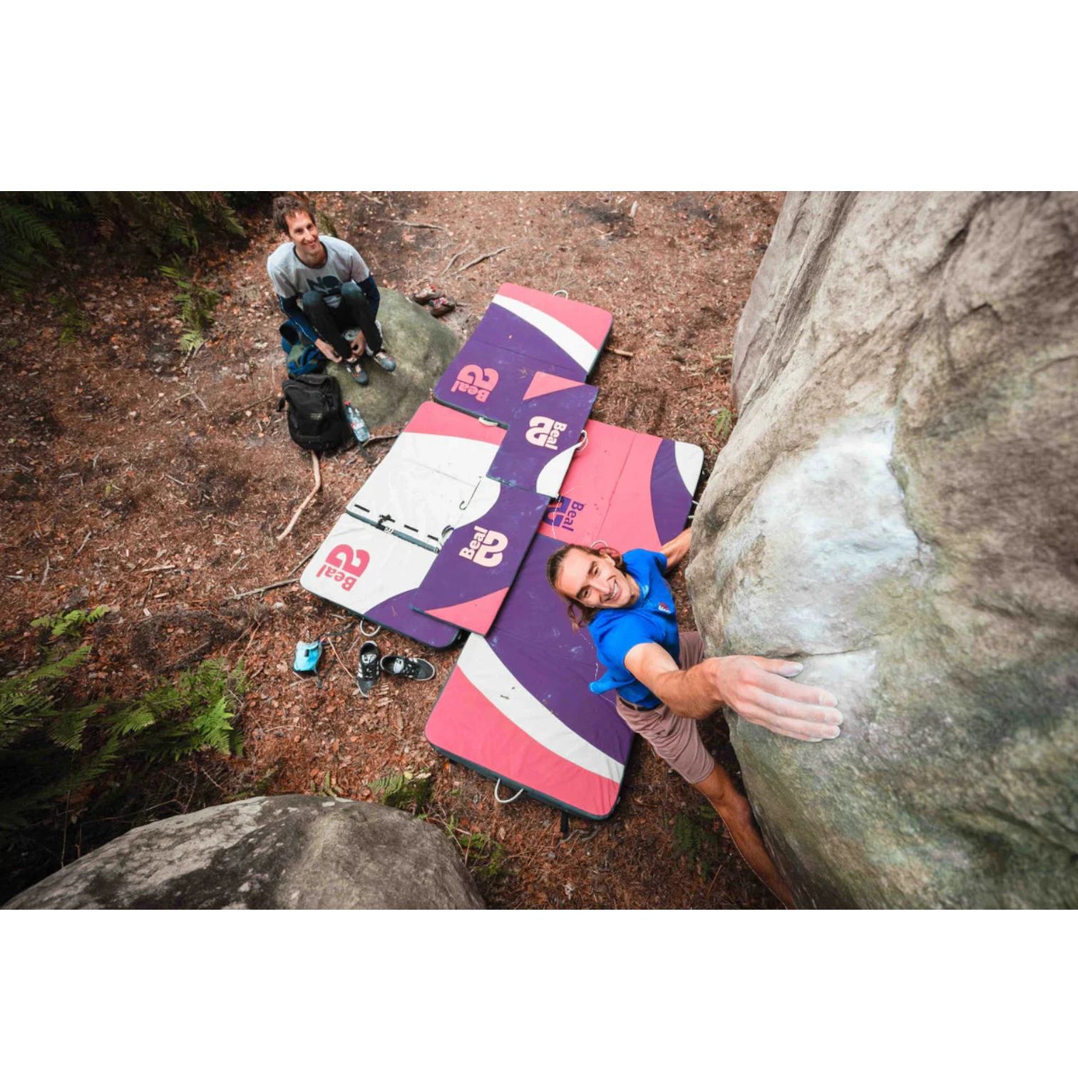 Escalador en roca usando Addition Pad de 4c+ para proteger la zona de recepción en un bosque