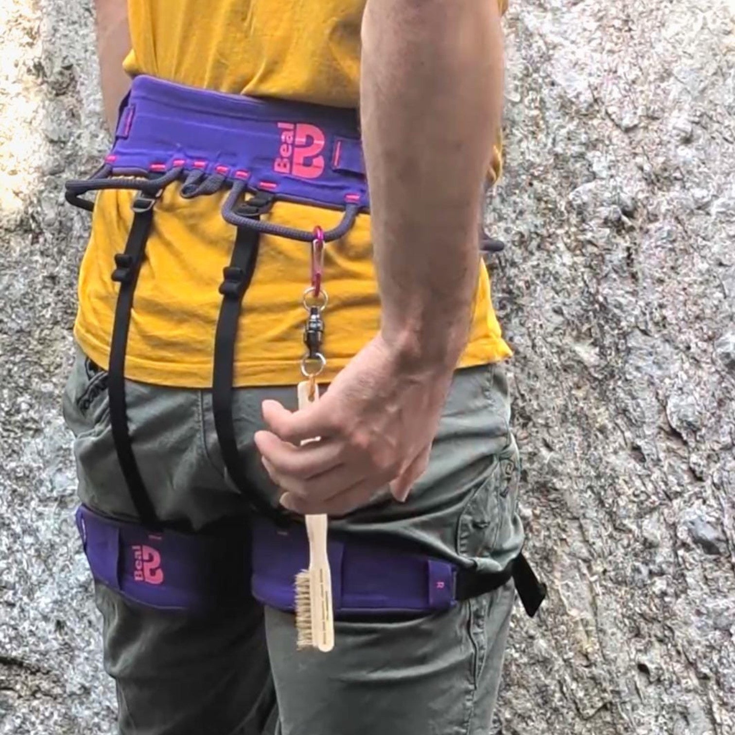 Escalador usando el sistema magnético 4c+ CLIPMAG para sujetar una brosse de limpieza al arnés en roca