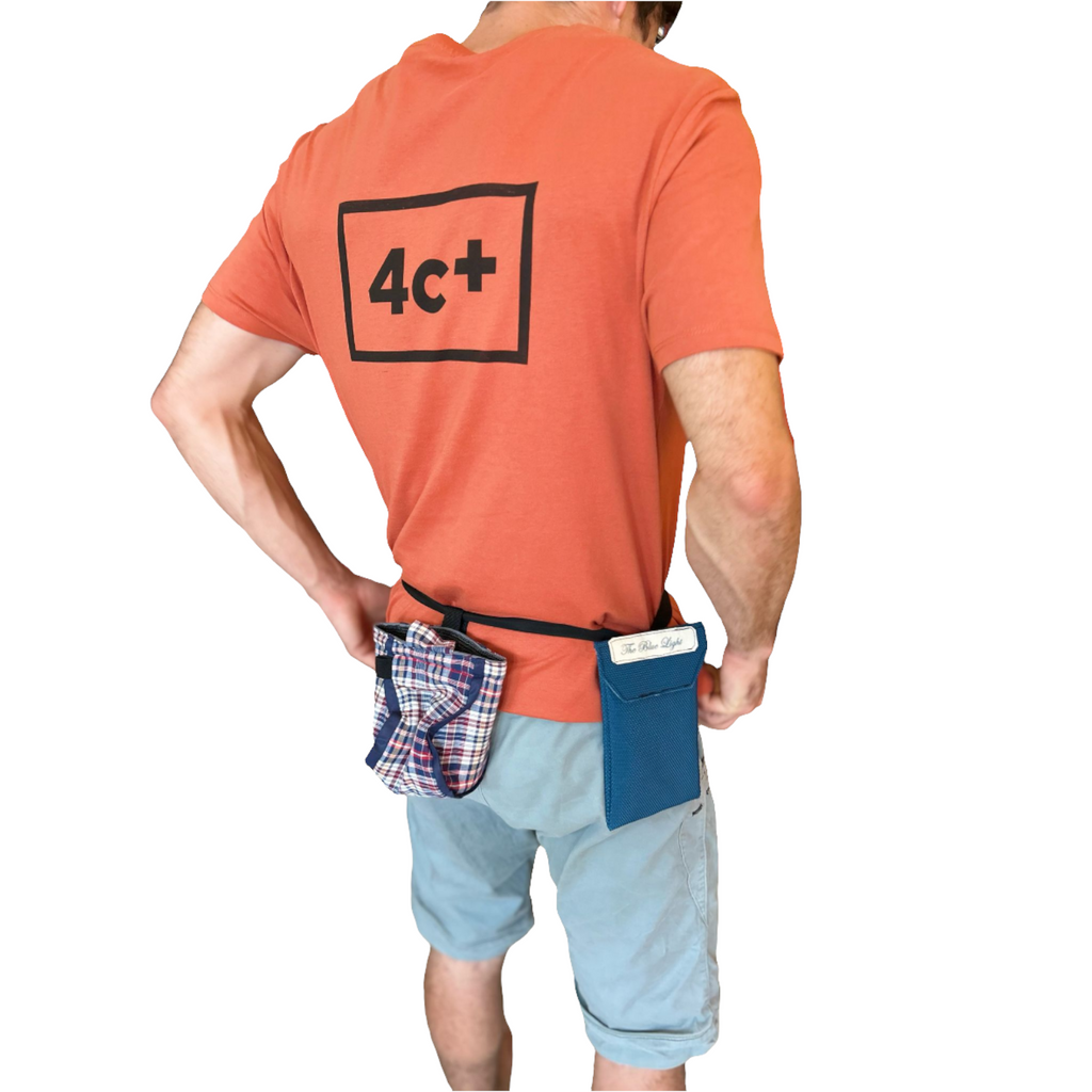 Grimpeur portant un porte-téléphone bleu 4c+ et un sac à magnésie à carreaux sur une ceinture réglable