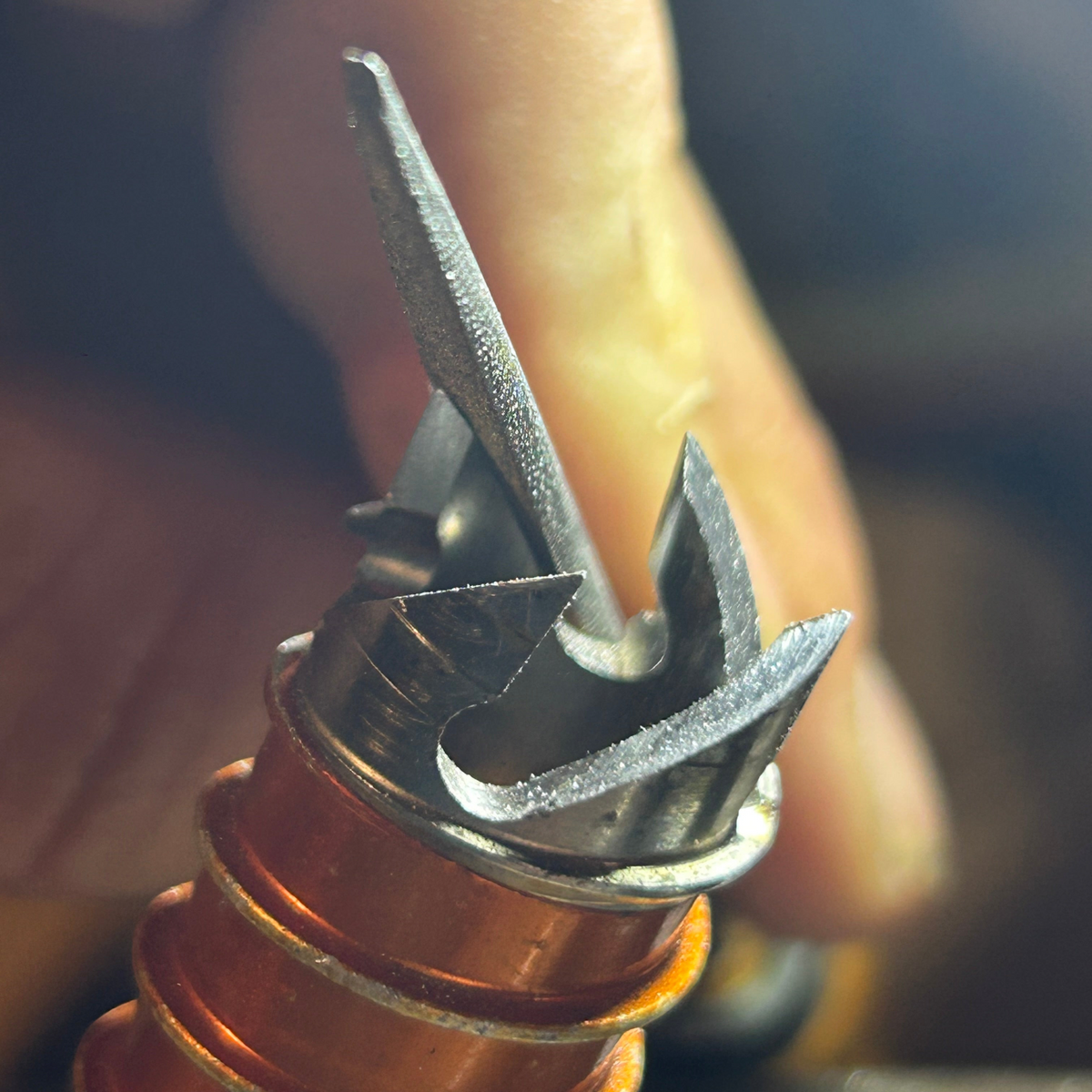 Affûtage de broche à glace en atelier 4c+, gros plan d’une main travaillant les dents d’une broche