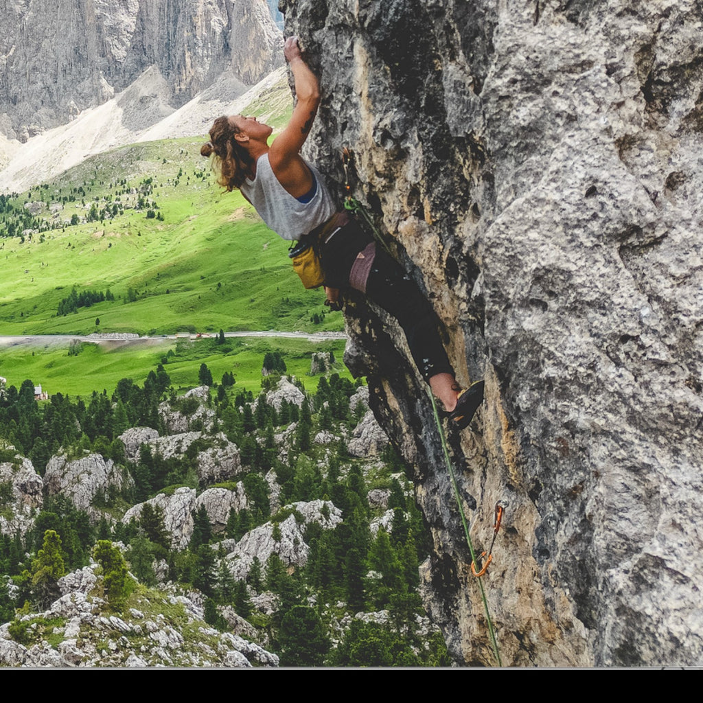 Escaladora con arnés 4c+ Cuesta Femme escalando una pared de roca en un paisaje montañoso de Chamonix